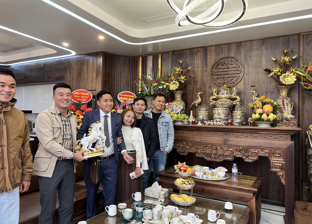 Tân gia khách hàng chụp ảnh cùng bộ bàn thờ gỗ óc chó